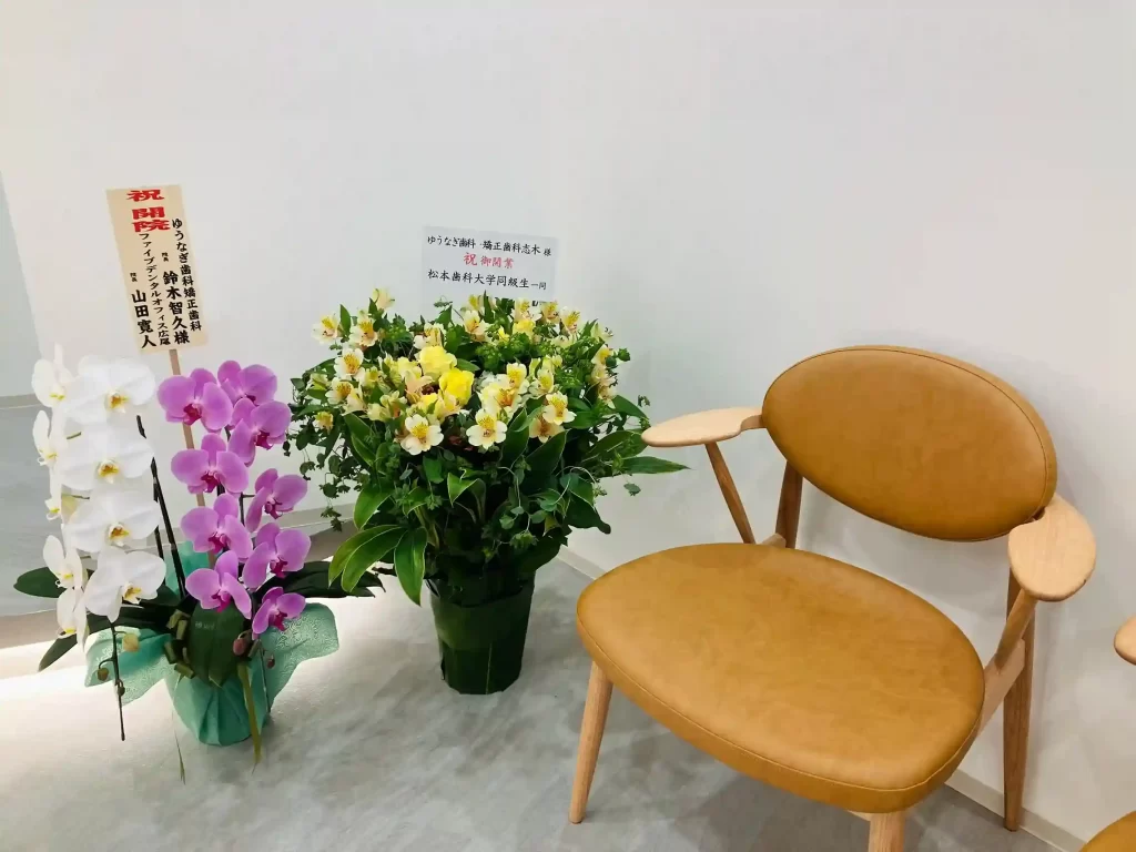 待合室の椅子横に並ぶお祝いのお花